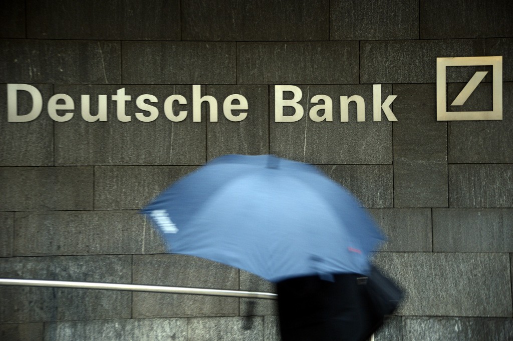FRANKFURT AM MAIN, GERMANY - JANUARY 29: A woman with a umbrella passes a logo of Deutsche Bank on January 29, 2013 in Frankfurt am Main, Germany. The annual results press conference for 2012 takes place on Thursday, January 31, 2013. (Photo by Thomas Lohnes/Getty Images)